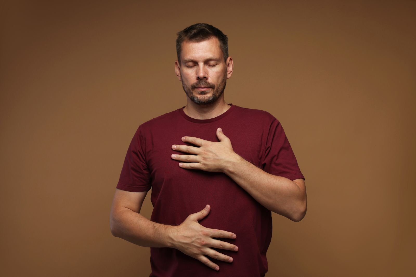 Calm person practicing a breathing exercise with hands on chest