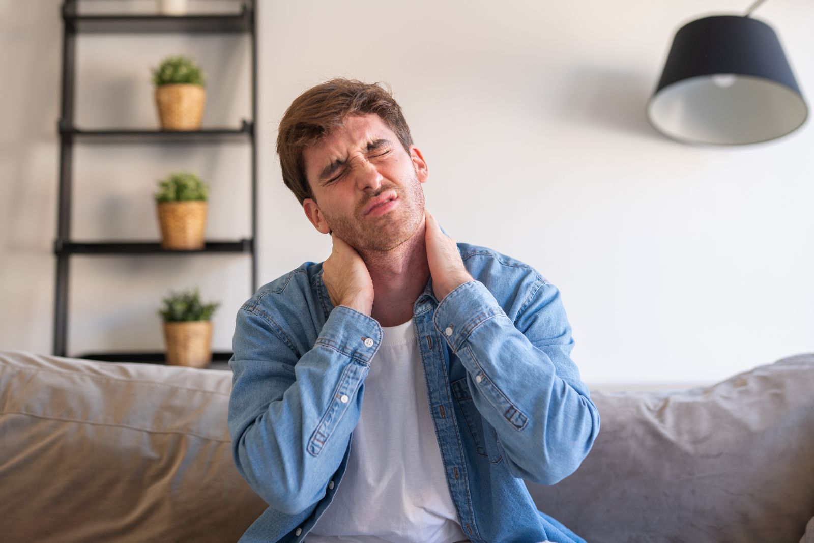 Man sitting on couch emotionally withdrawn and tired