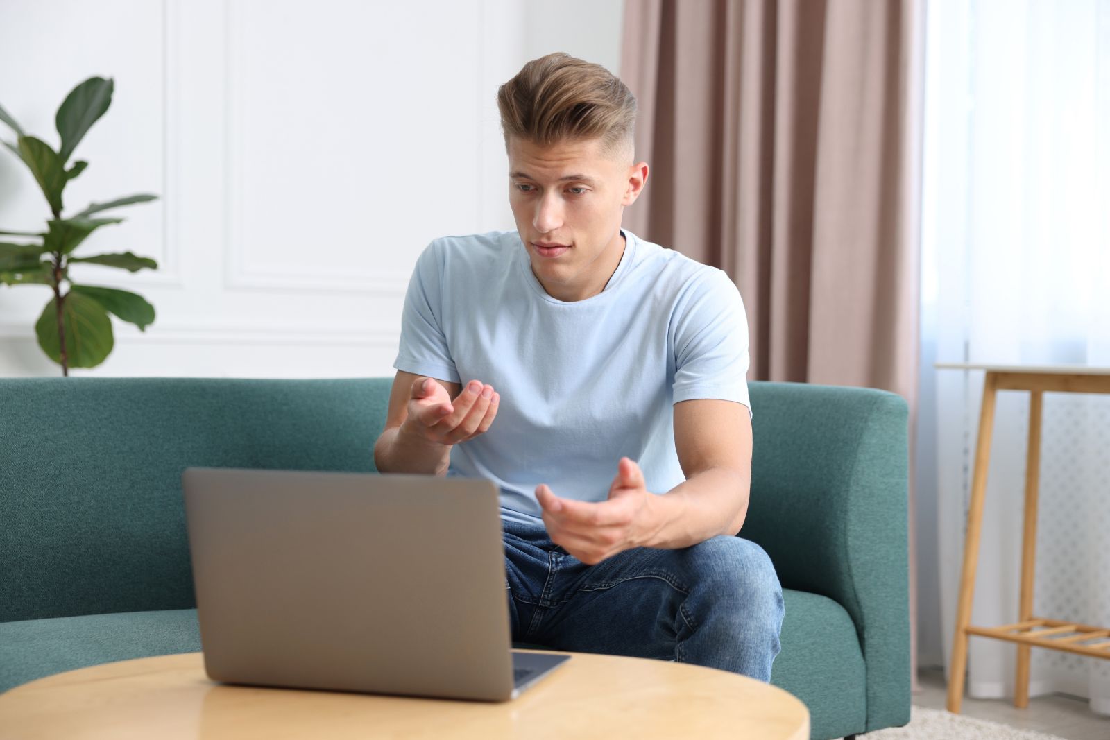 Man on a private telehealth visit from home with laptop