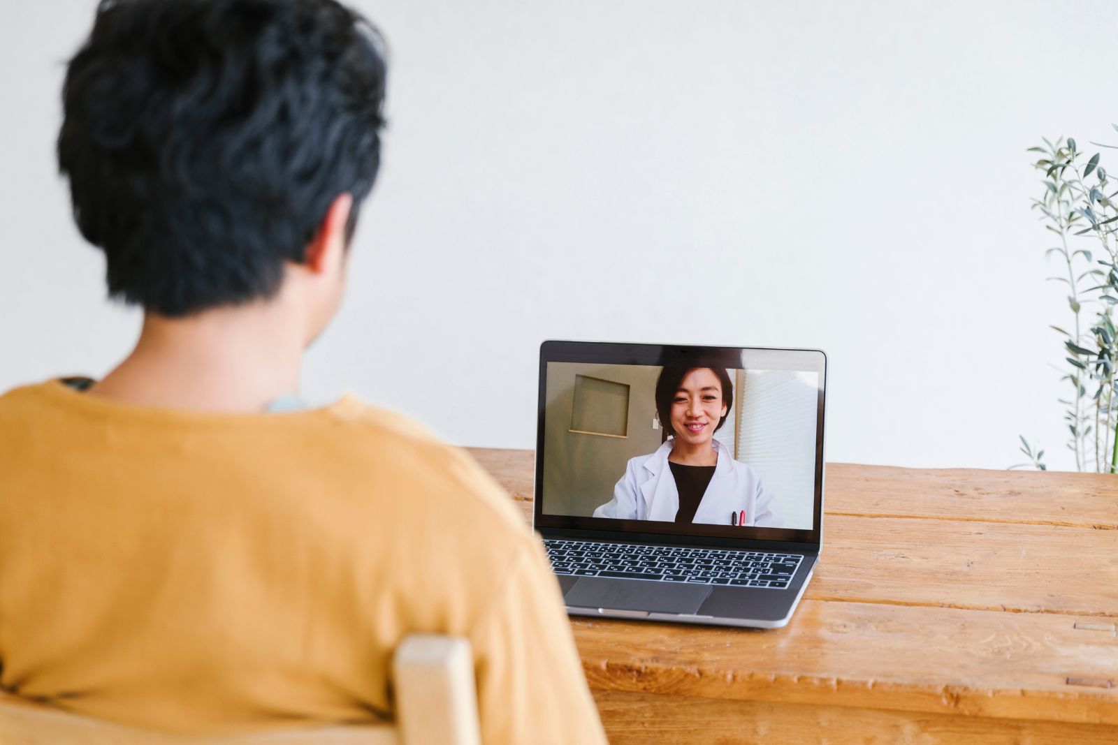 Adult using a laptop for a healthcare video visit at home