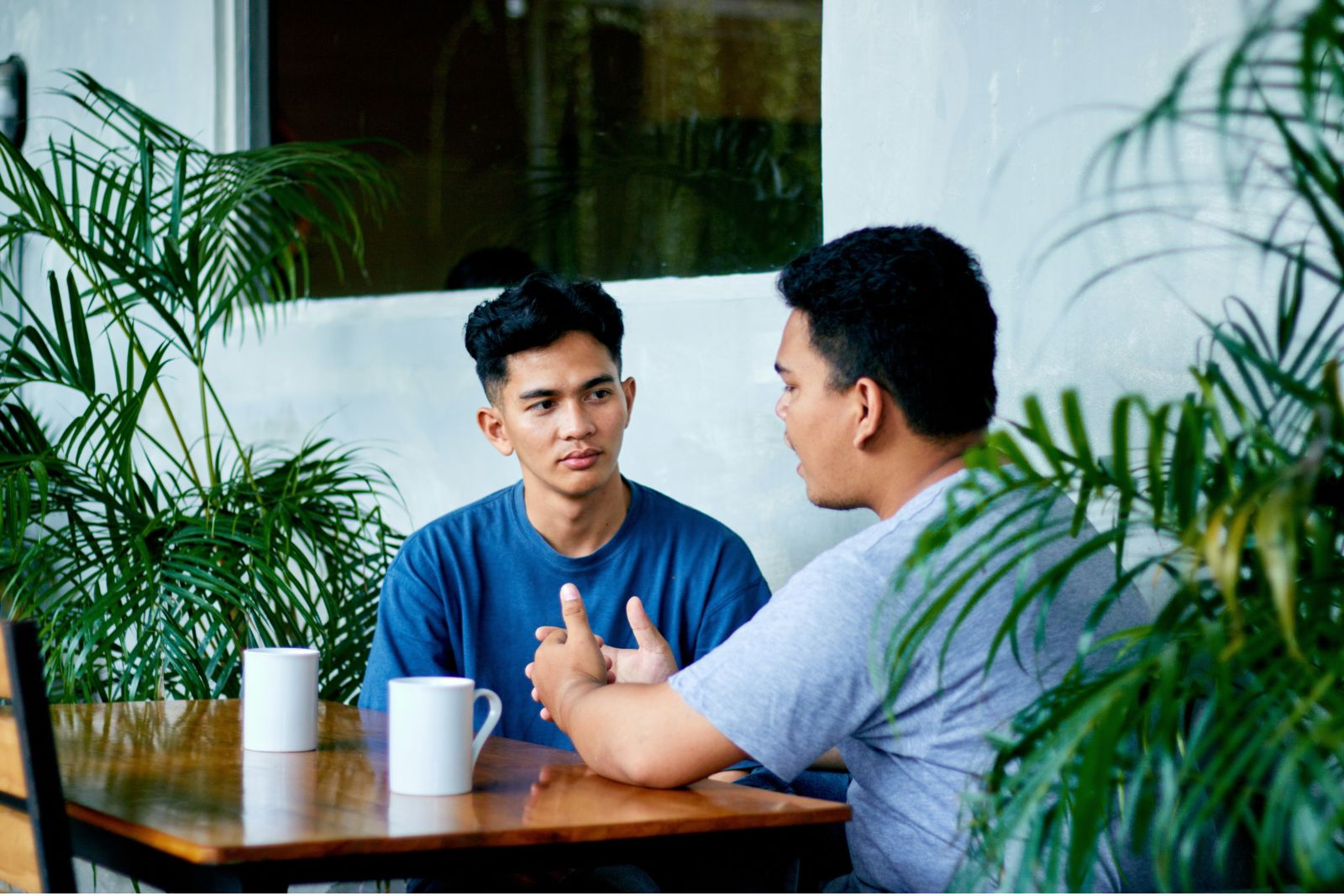 Two adults talking together at a kitchen table